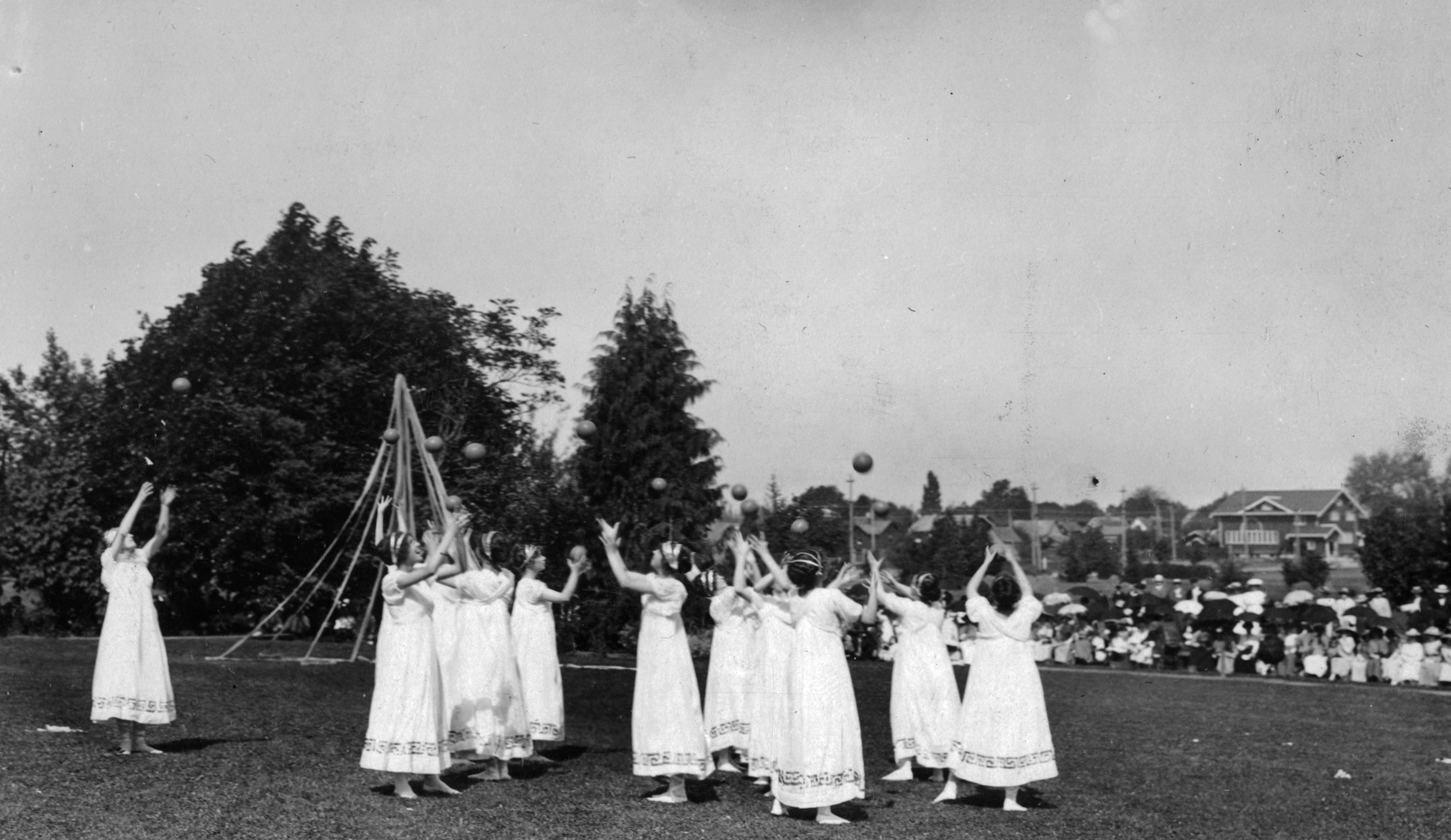 Image of women dressed as Greek maidens playing ball in May Day pageant
