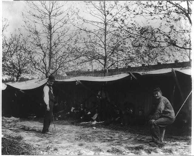 Image of two men in front of tent camps