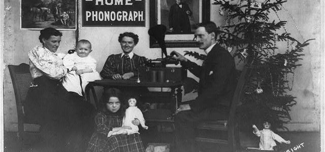 Man, two women and two children listening to phonograph