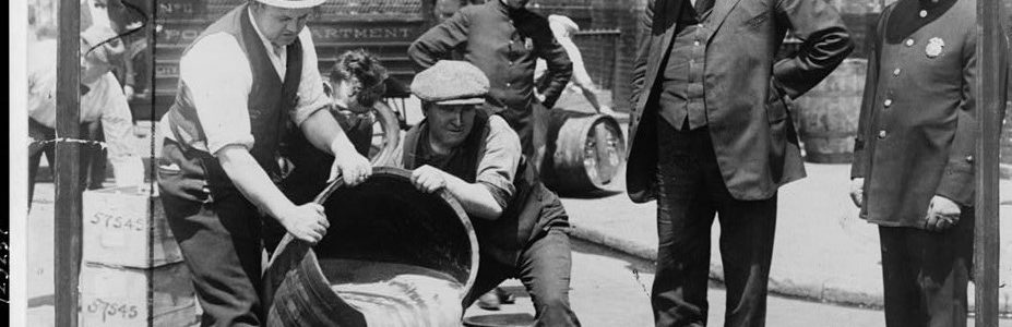 Agents pouring liquor into sewer following a raid during Prohibition