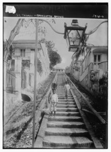 Black and white photograph of two children walking down steps in Charlotte Amalie