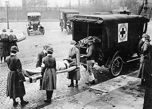 Members of the American Red Cross remove a victim of influenza from a house
