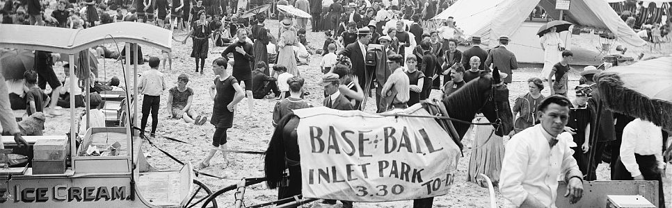 Black and white photograph of people on the beach behind an ice cream wagon with a horse wearing a banner that reads, "Base-ball Inlet Park 3.30 to-day"